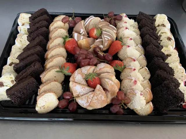 Sweet platter of brownies, cake slices, strawberries and grapes
